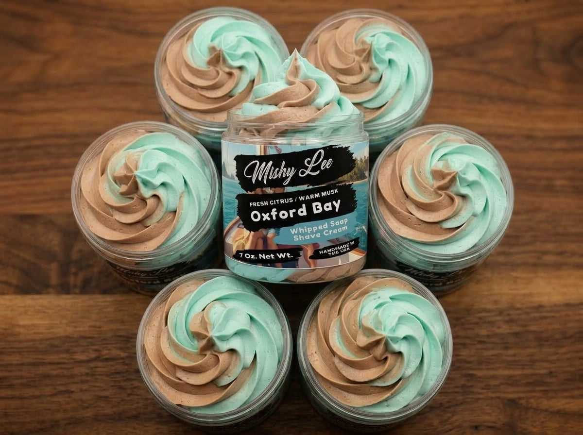 Five small jars of teal and tan whipped soap swirls surrounding main Oxford Bay tub