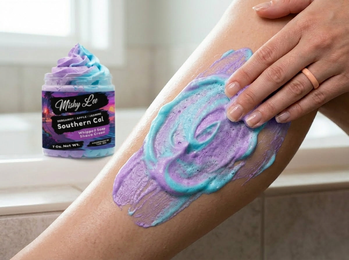 Hand spreading purple and blue whipped soap on skin with a second layer of lather