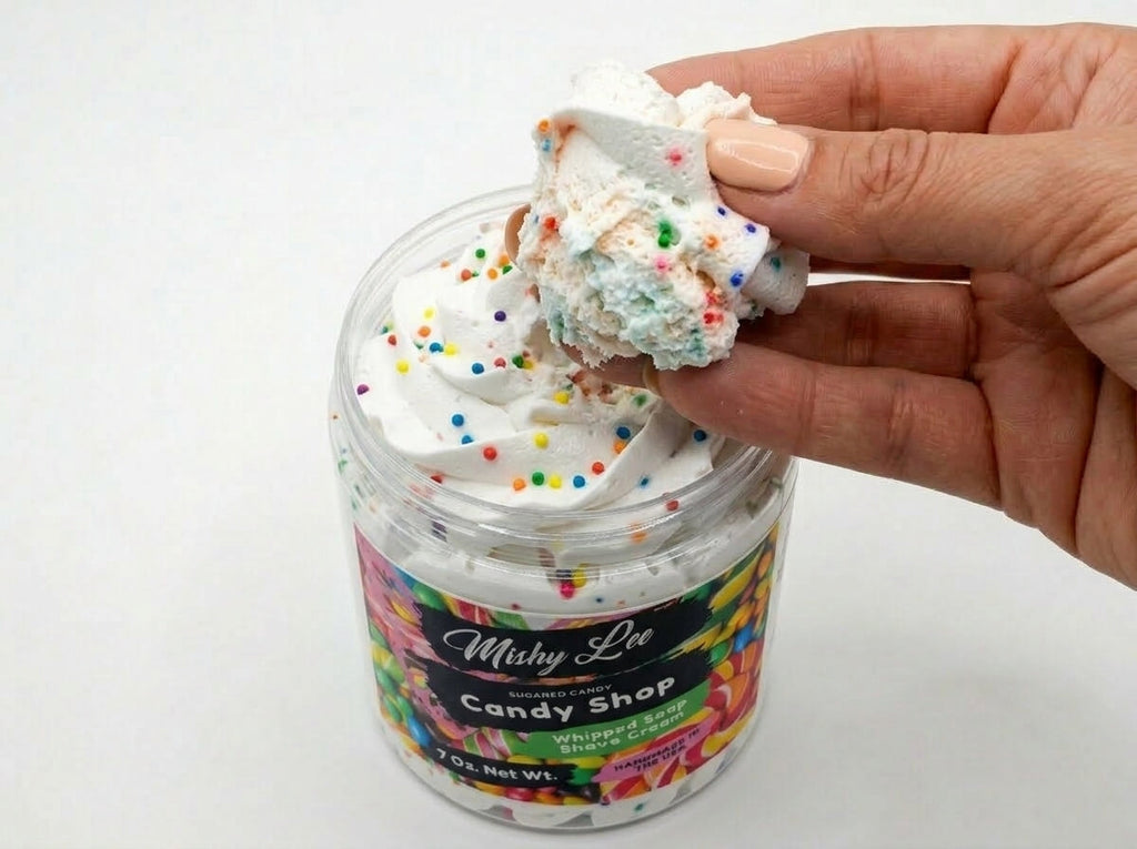 Hand holding scoop of white whipped soap with colorful sprinkles from Mishy Lee jar