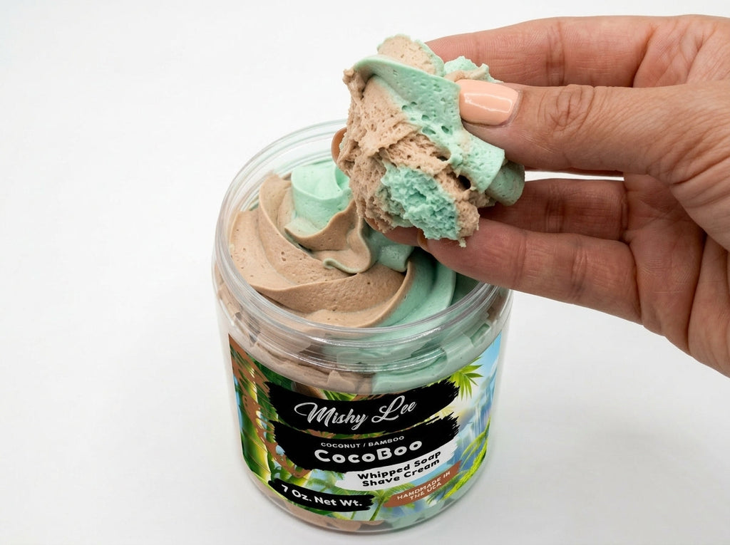 Hand holding a scoop of mint and tan whipped soap and shave cream from CocoBoo jar