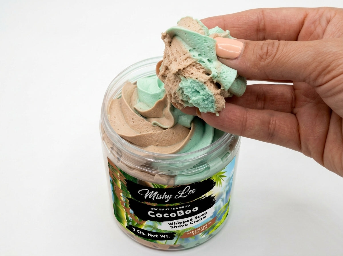 Hand holding a scoop of mint and tan whipped soap and shave cream from CocoBoo jar