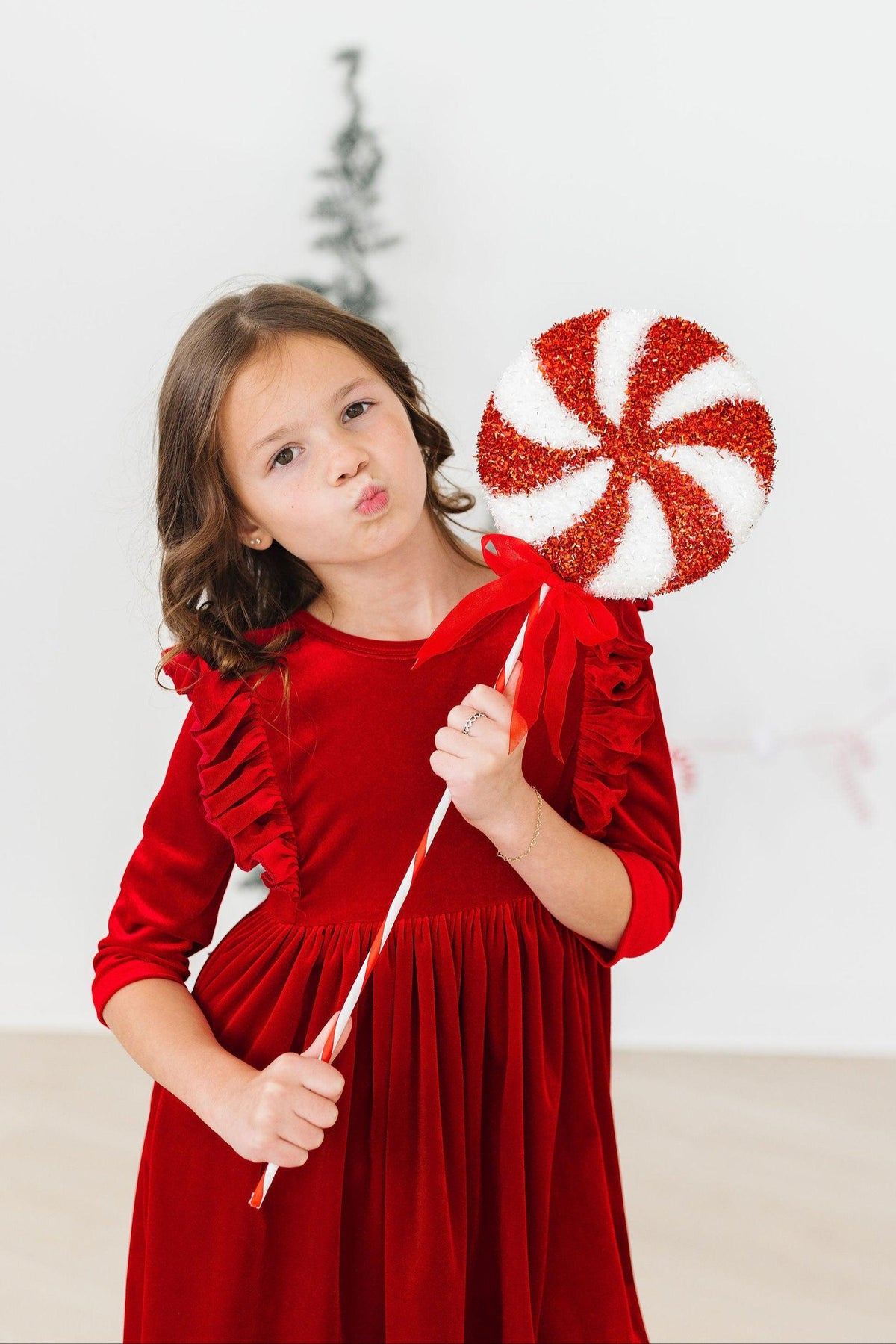 Red velvet dress with ruffle-trim shoulders, gathered waist, and long sleeves