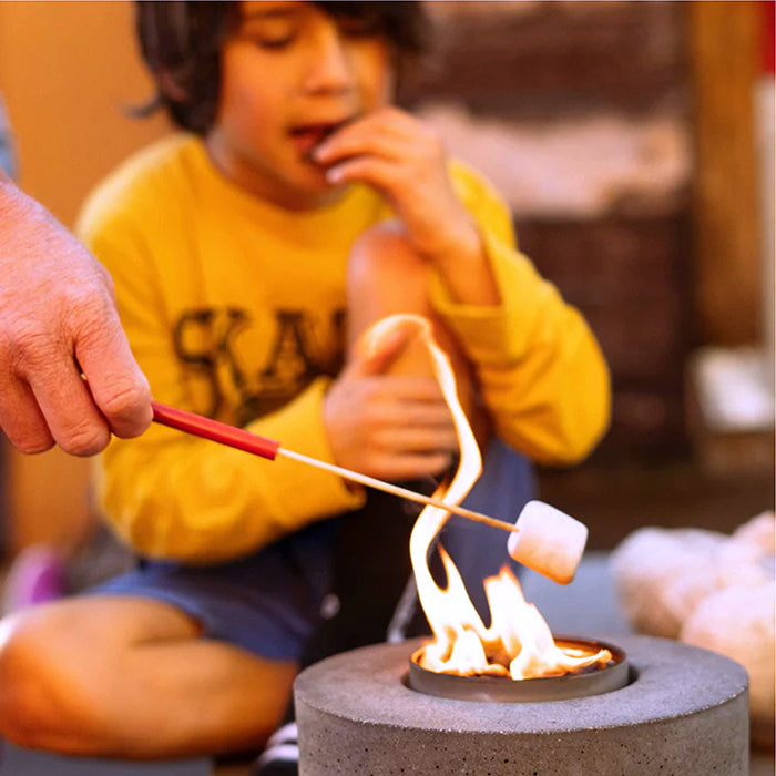 Red reusable skewer with white tip holding food over an open flame