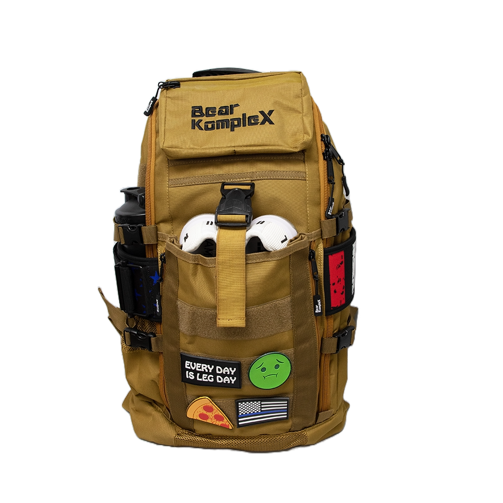 Tan tactical backpack with front organizer pockets, straps, and Bear KompleX patch