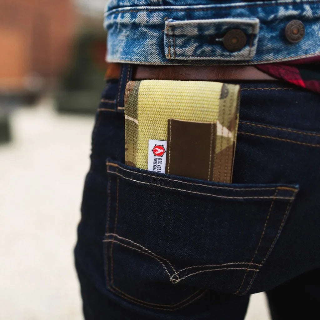 Notebook cover in green-and-tan fabric inside a denim jeans pocket with red patch