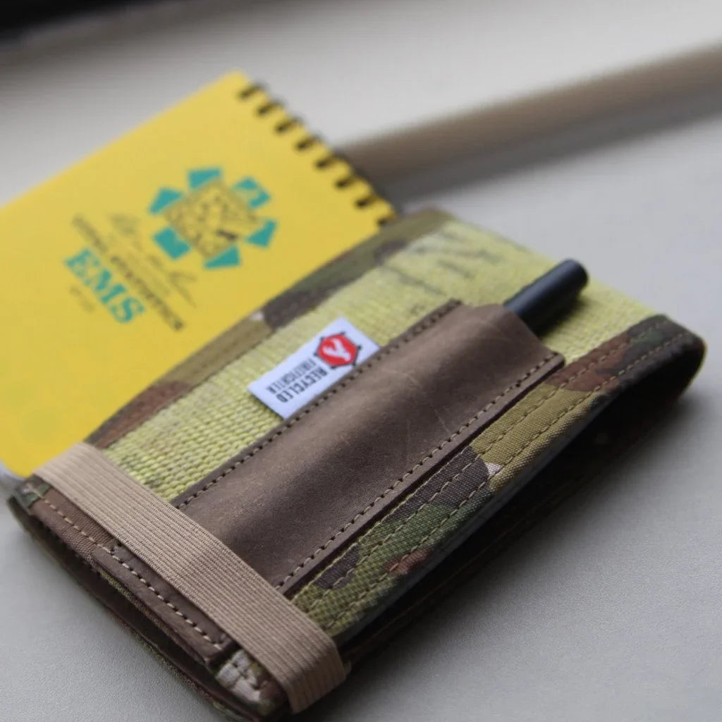 Firehose notebook cover with elastic strap and leather pen pocket, holding notebooks