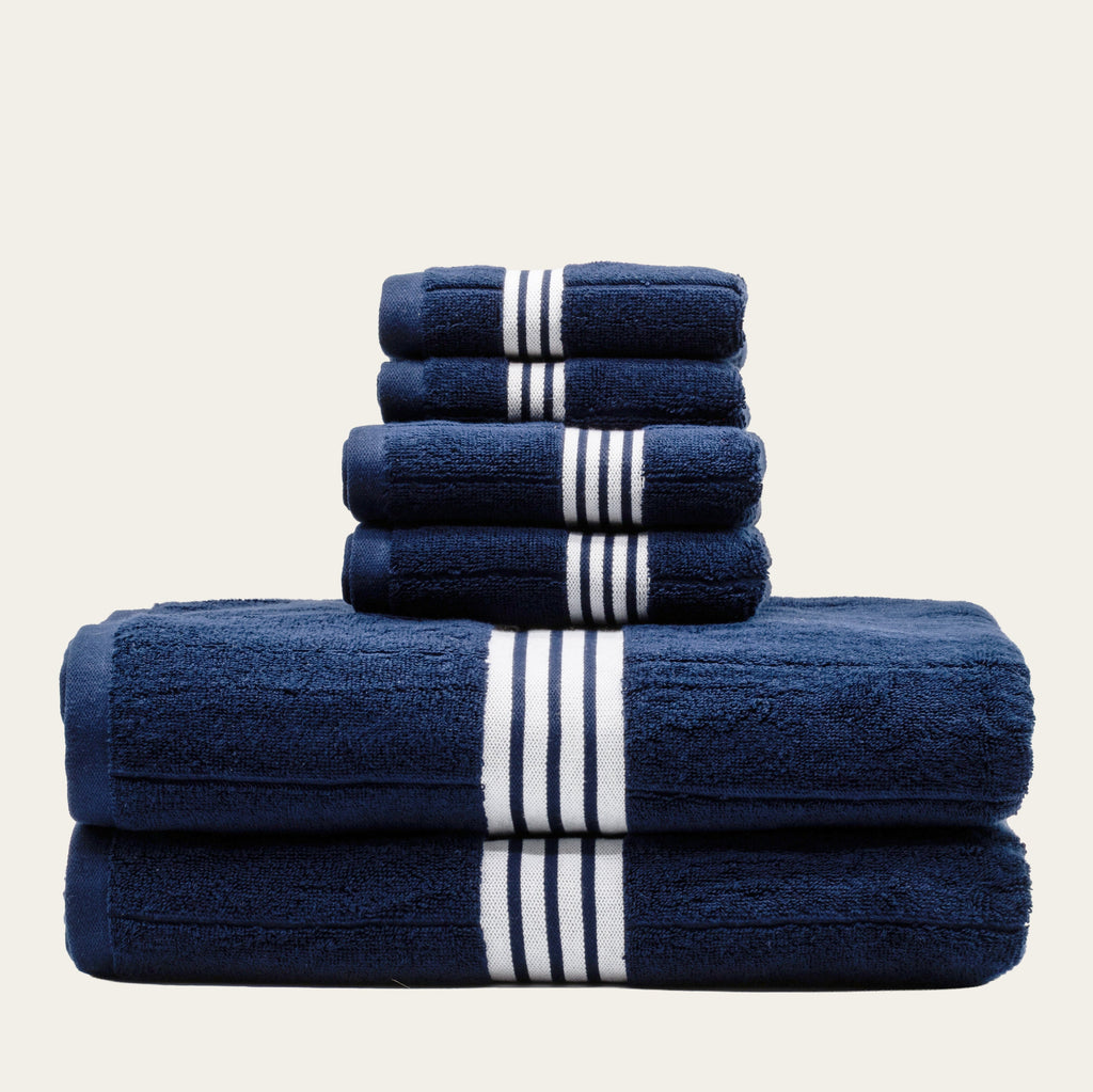 Navy cotton towels with white striped bands, layered fold with multiple towels