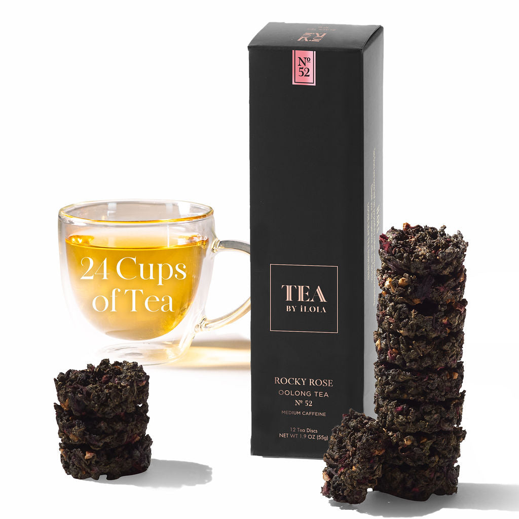 Rocky Rose No. 52 tea box and compressed tea discs beside a glass cup of brewed tea.