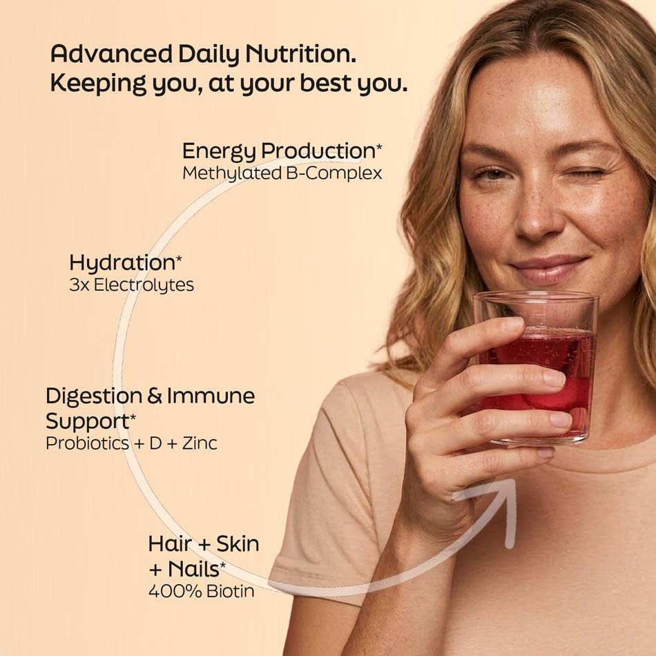 Raspberry acai energy drink glass held by woman, with red-colored beverage
