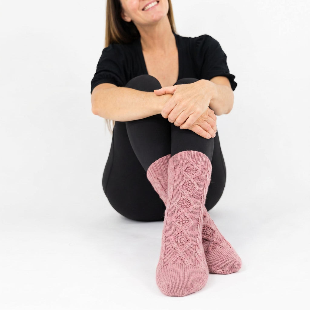 Rose pink slipper socks with textured knit and white sherpa cuff, shown on foot