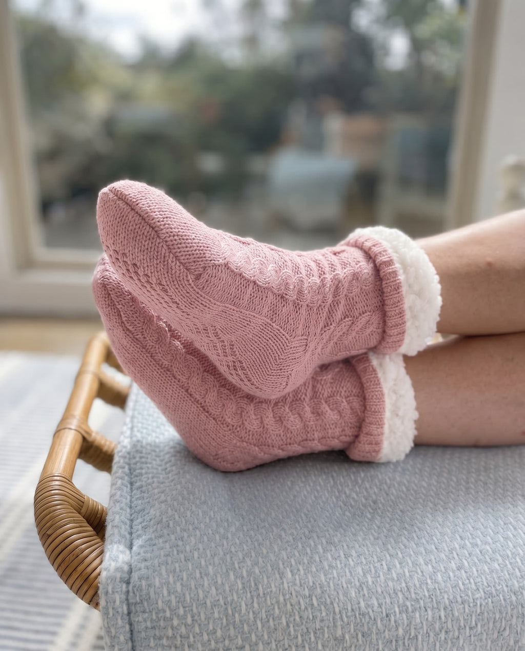 Rose pink slipper socks with cable knit pattern and fluffy white cuff