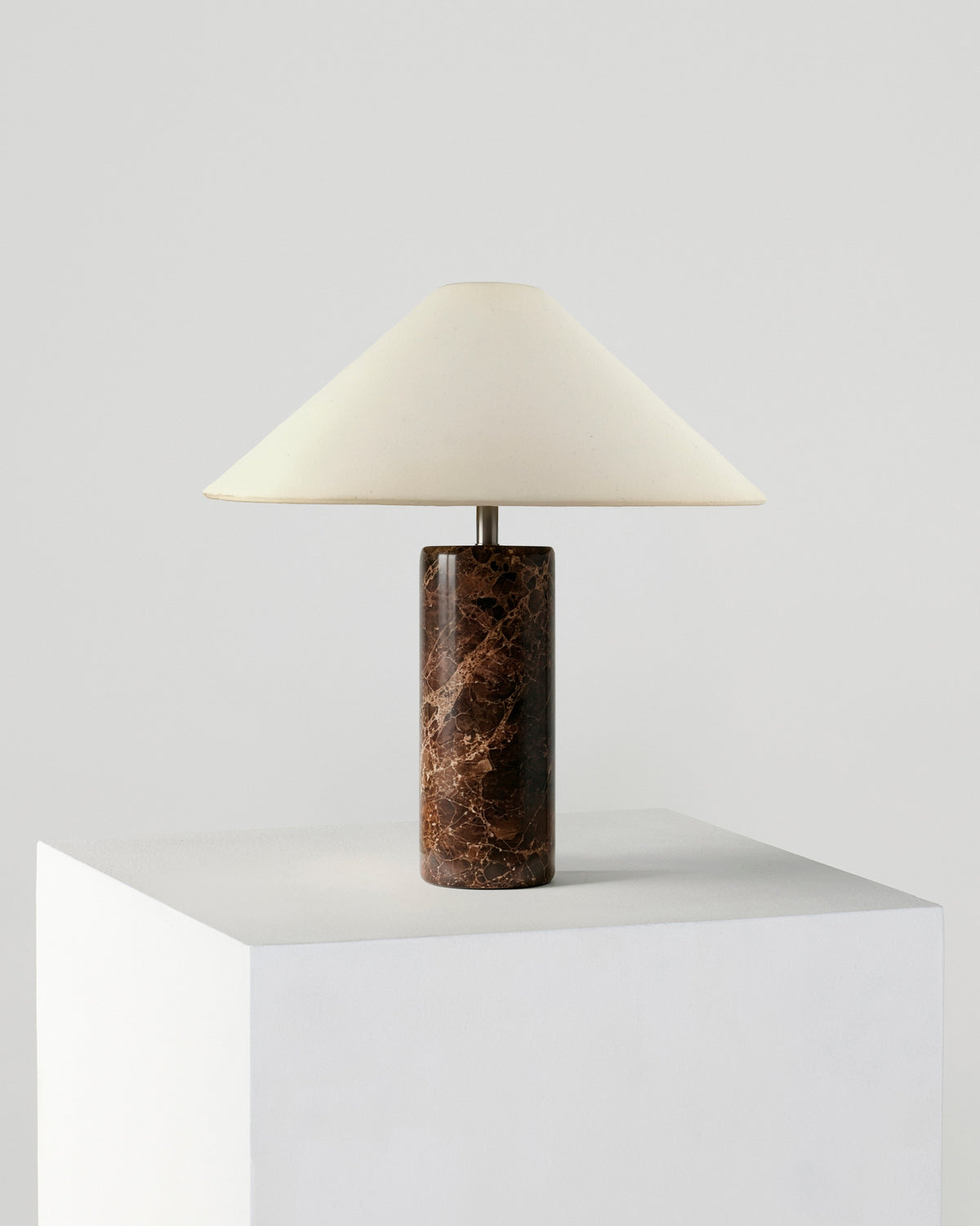 Table lamp with cream fabric shade and dark brown marble cylindrical base.