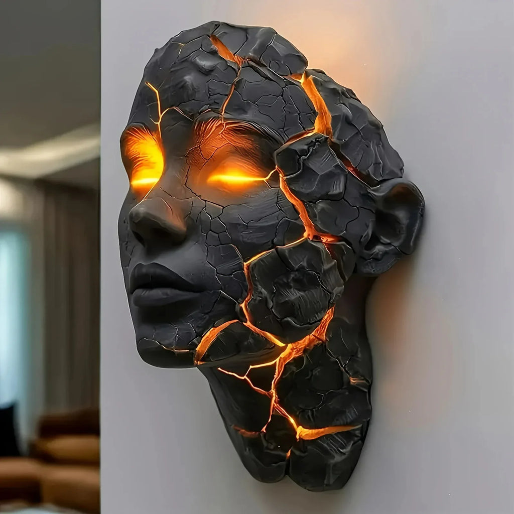 Black cracked-face wall lamp figurine with bright orange glow through glowing fissures
