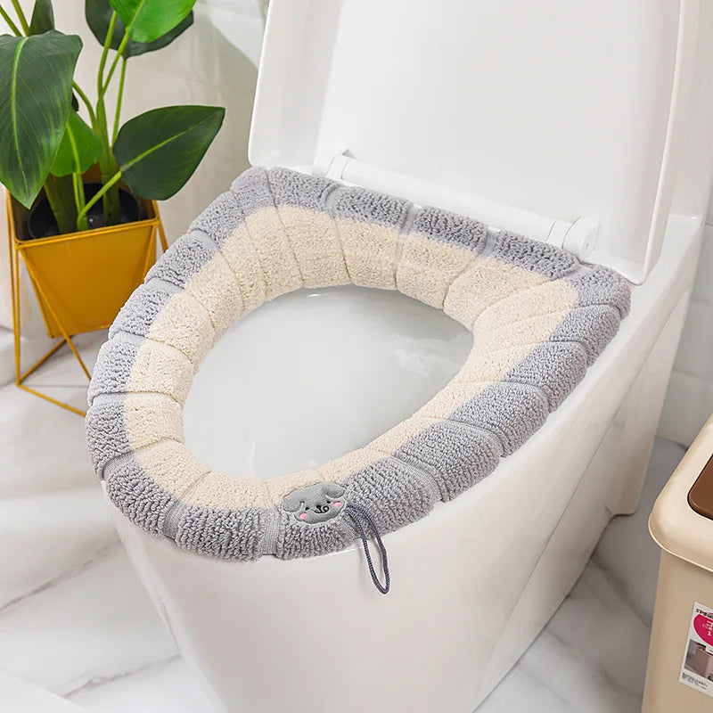 Beige plush toilet seat cover mat with gray trim and animal patch