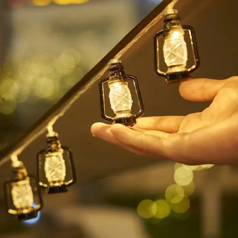 Hand holding solar bottle lantern string light with glowing glass lamp