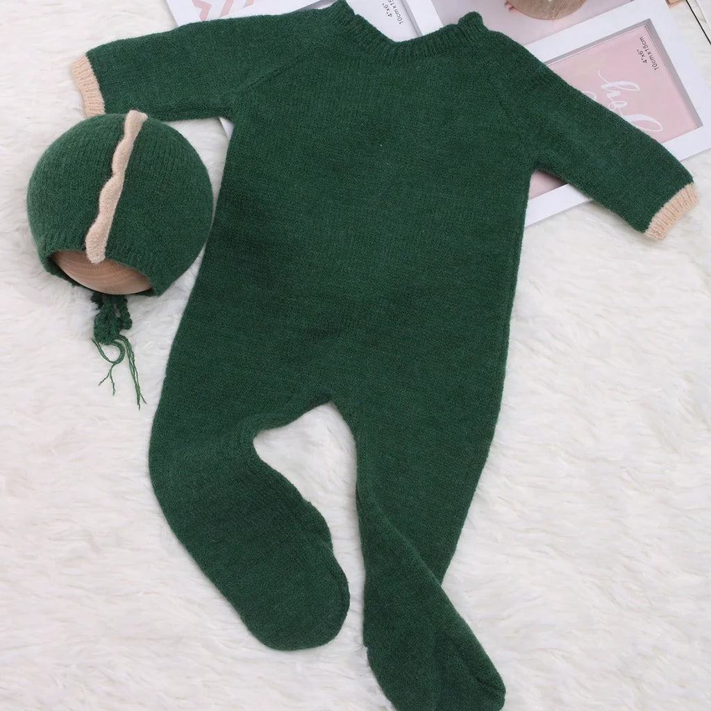 Green knit dinosaur one-piece pajama suit with long sleeves and footed legs
