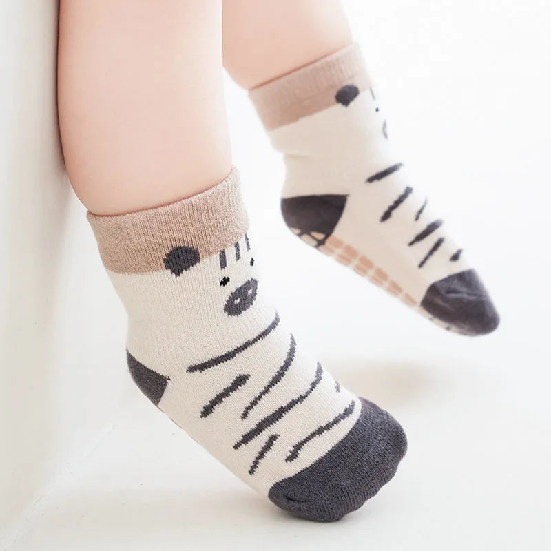 Kids non-slip floor socks with panda-like faces and zebra stripes, grippy sole