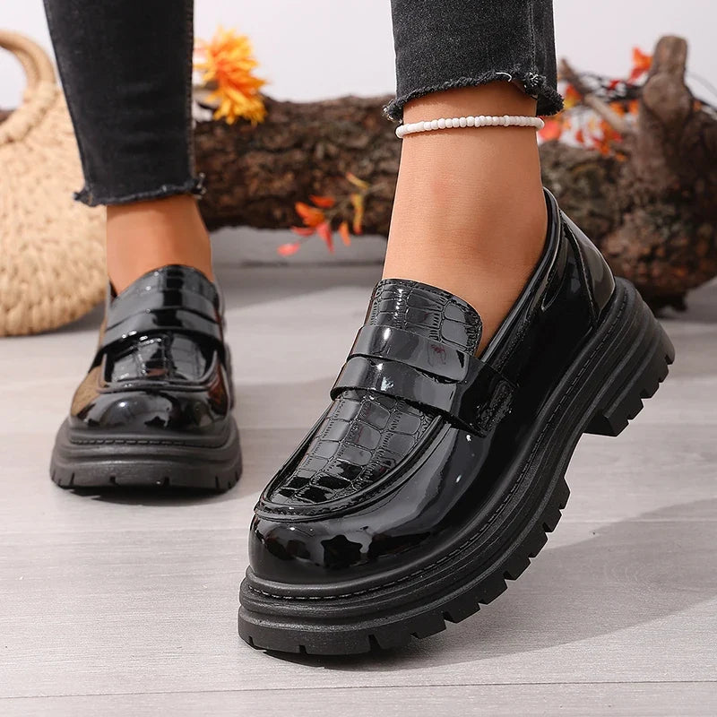 Black patent leather chunky platform loafers with round toe and thick tread sole