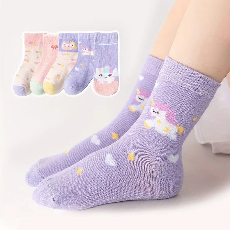 Kids mid-calf socks in lavender with unicorn and star designs, worn on a leg.