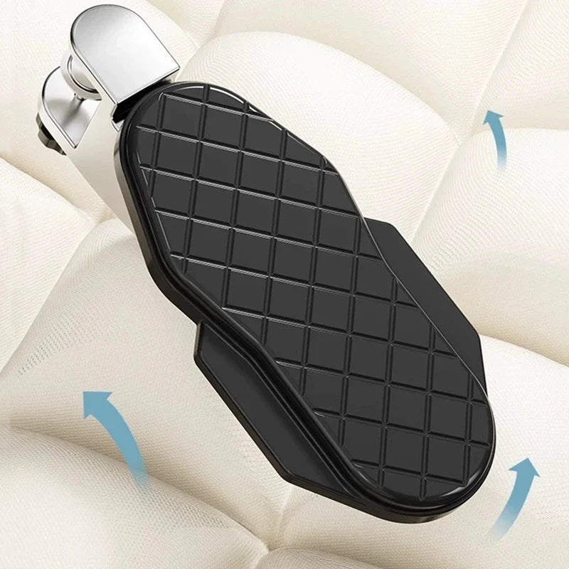 Black curved desk wrist rest with grid pad, angled over armchair