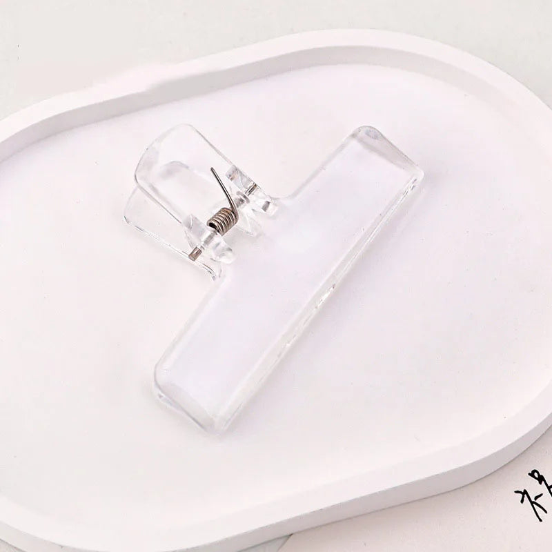 Clear ice jelly clip with transparent acrylic body and spring clasp on tray