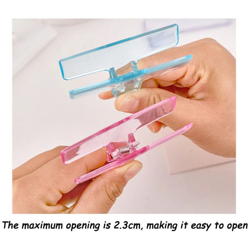 Hand holding an ice jelly clip opening wide in blue and pink colors