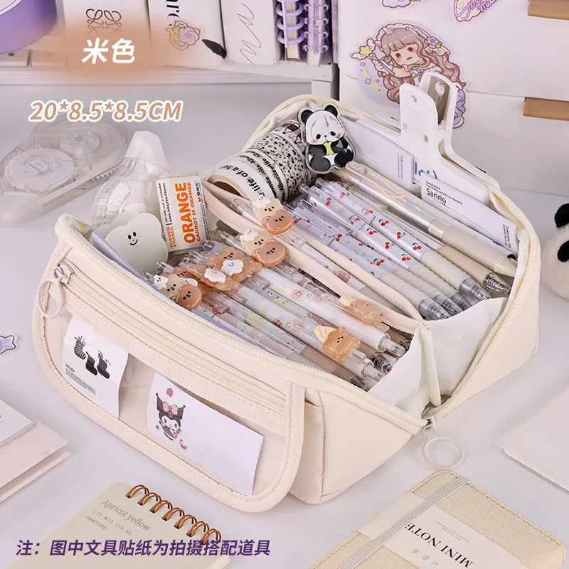 Cream zip pencil case open with pens inside and front character label pocket