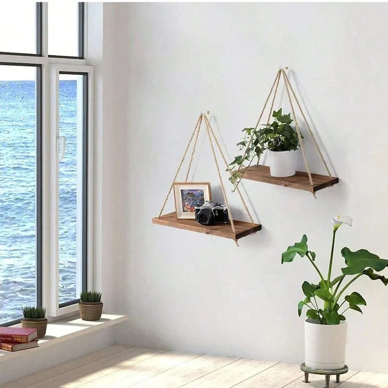Set of two hanging wooden shelves with hemp rope, holding plants and decor items