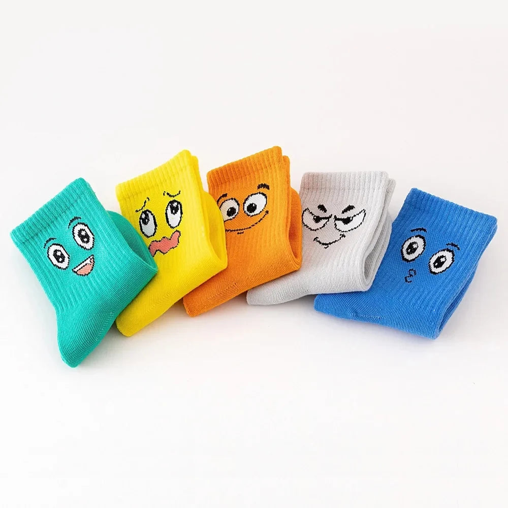 Kids crew socks 5-pair set with funny faces in teal, yellow, orange, white, and blue.