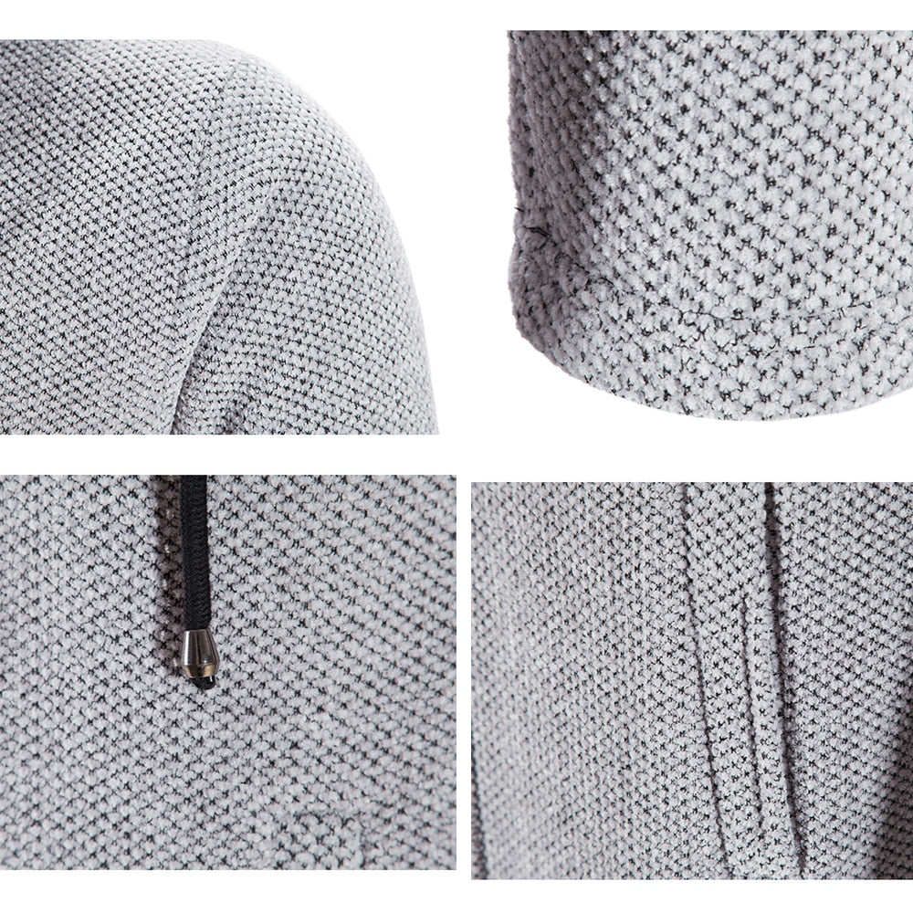 Close-up of light gray knit cardigan: textured fabric, zipper pull, seam detail