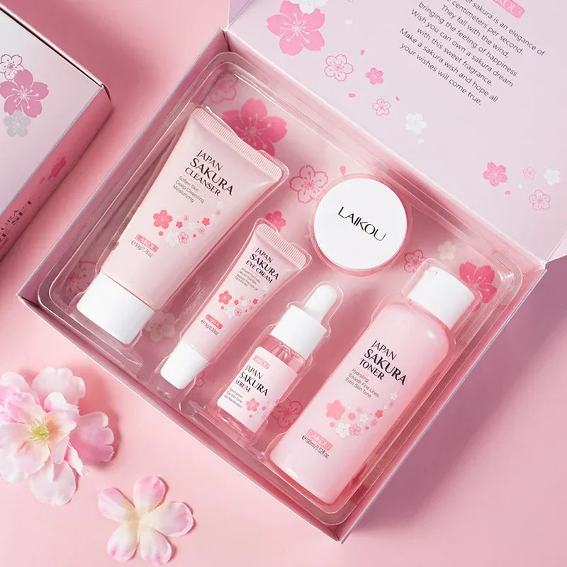 Sakura skincare set items in clear tray: five pink skincare bottles and cream jars