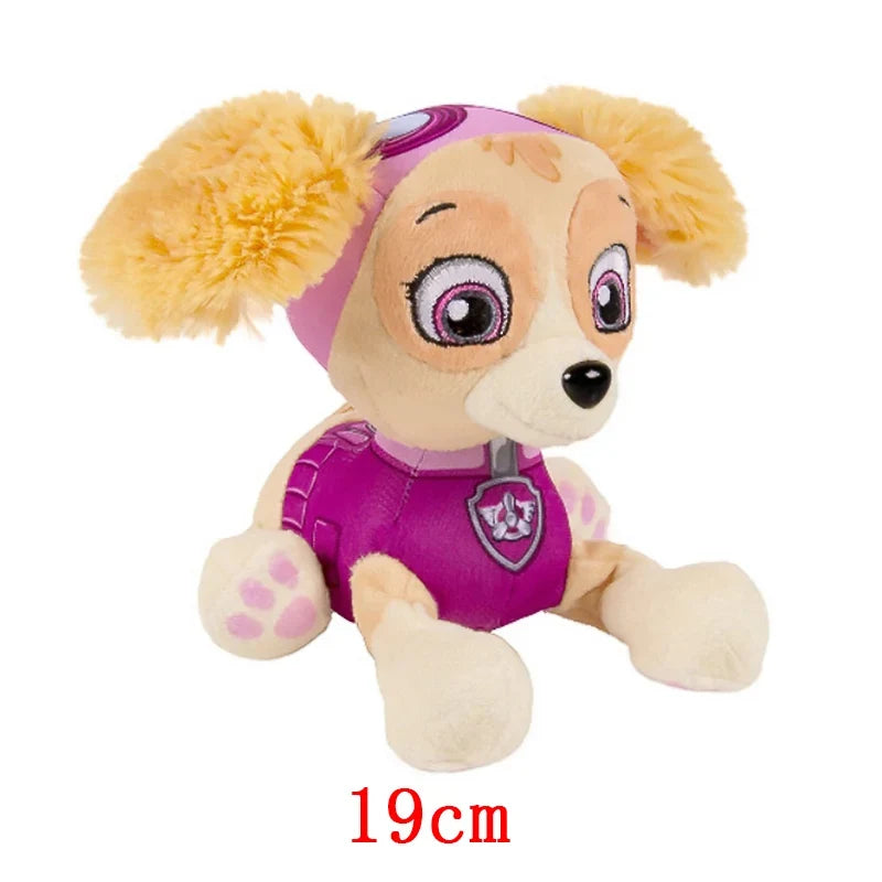 Tan plush puppy doll with pink harness and fluffy ear pom-poms, seated stuffed toy