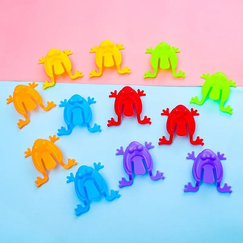 Assorted colorful frog trampoline toys, green red purple orange yellow frogs on blue surface