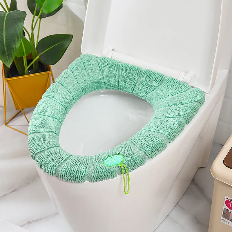 Green plush toilet seat cover mat with handle, soft looped terry fabric.
