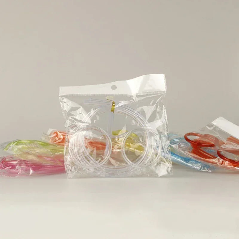 Assorted packaged novelty straw glasses with orange, pink, and blue straws