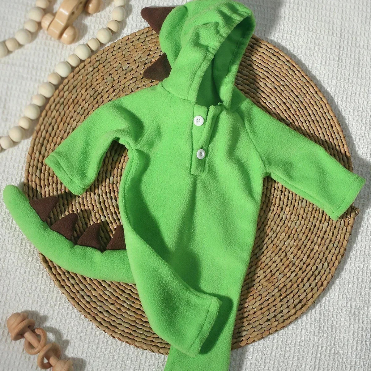 Green dinosaur hooded baby jumpsuit with button placket and brown spikes