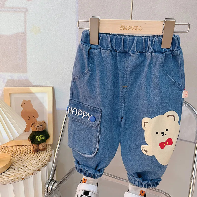 Blue denim jogger pants with teddy bear face patch and “HAPPY” side pocket