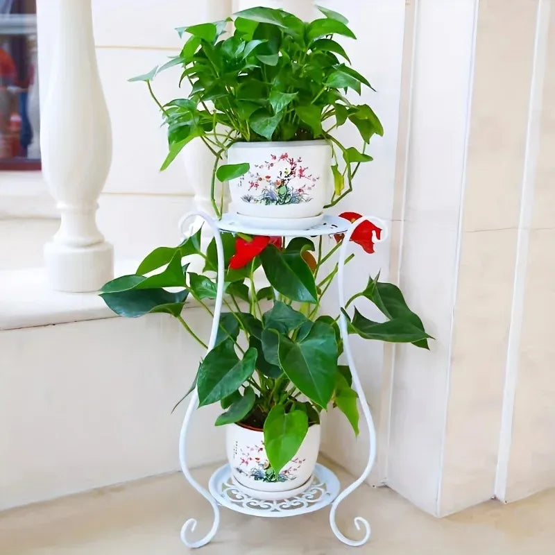 White multi-tier metal flower stand holding large leafy plants in pots