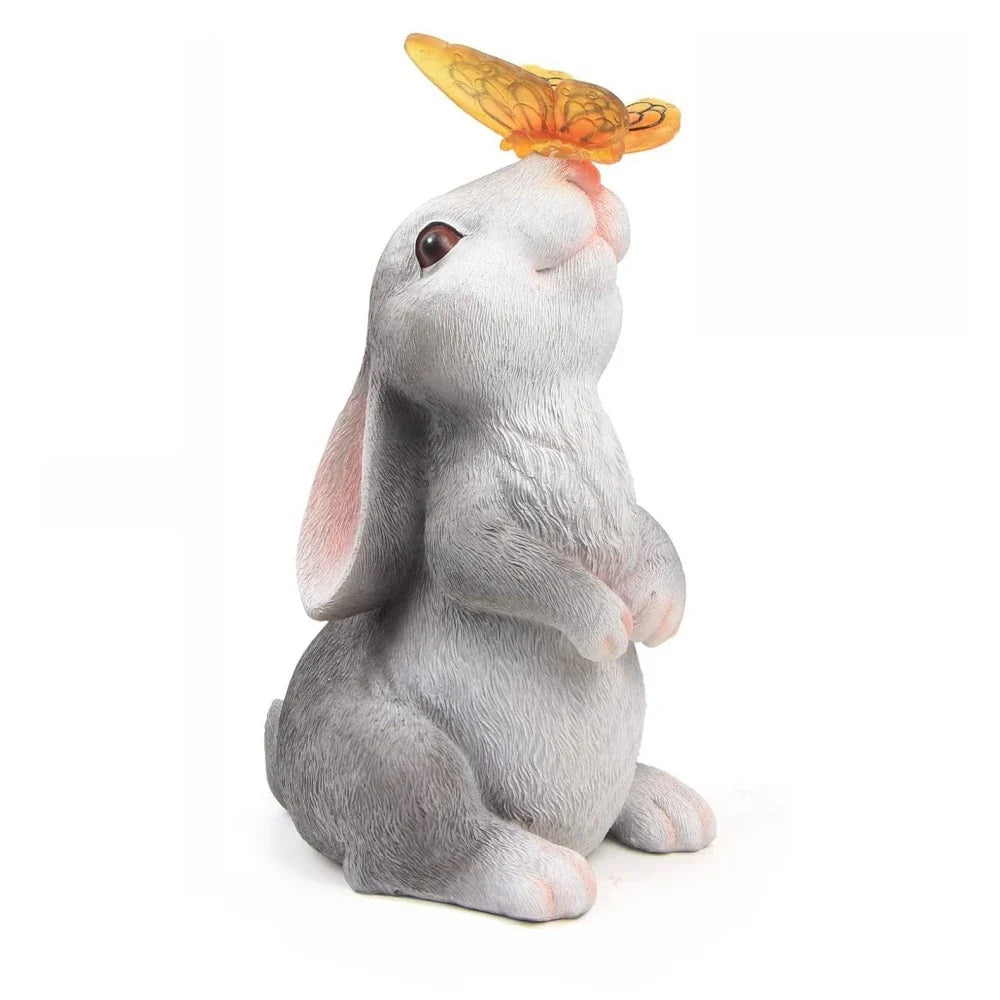 Sitting light-up rabbit statue with golden butterfly topper and flower bouquet in hand