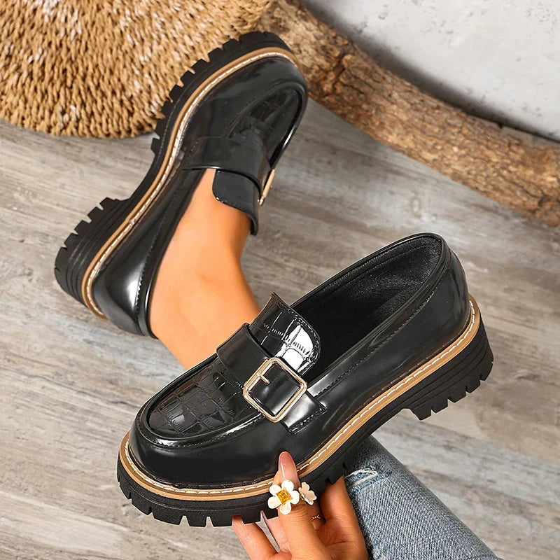 Black patent leather loafers with square buckle strap and chunky tread platform sole