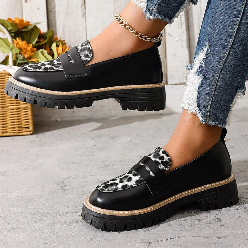 Black platform loafers with leopard print top panel and two buckle straps.