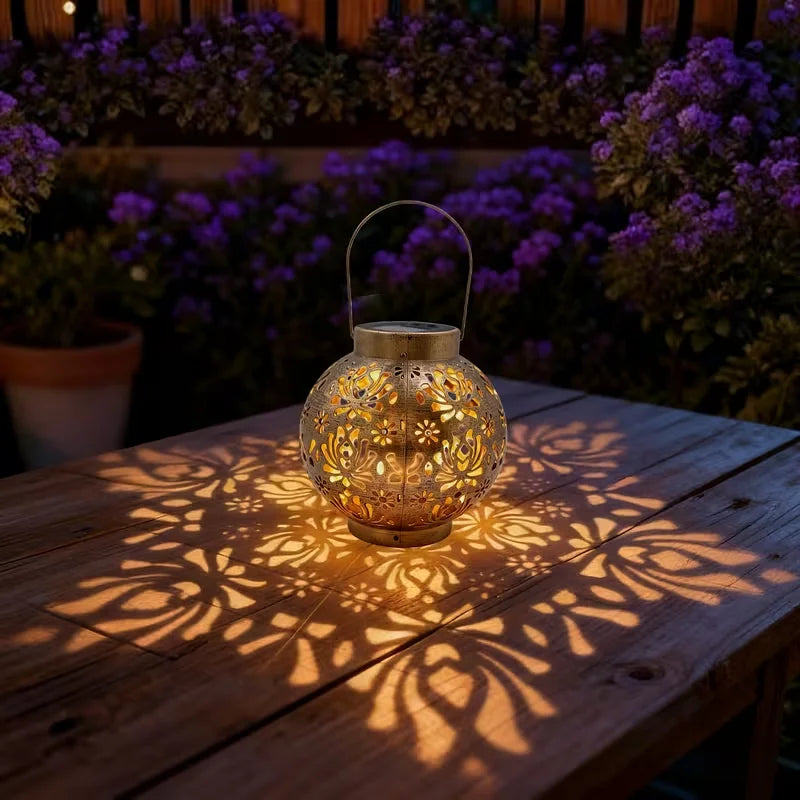 Bronze iron solar lantern with carved globe cutouts, warm light glow