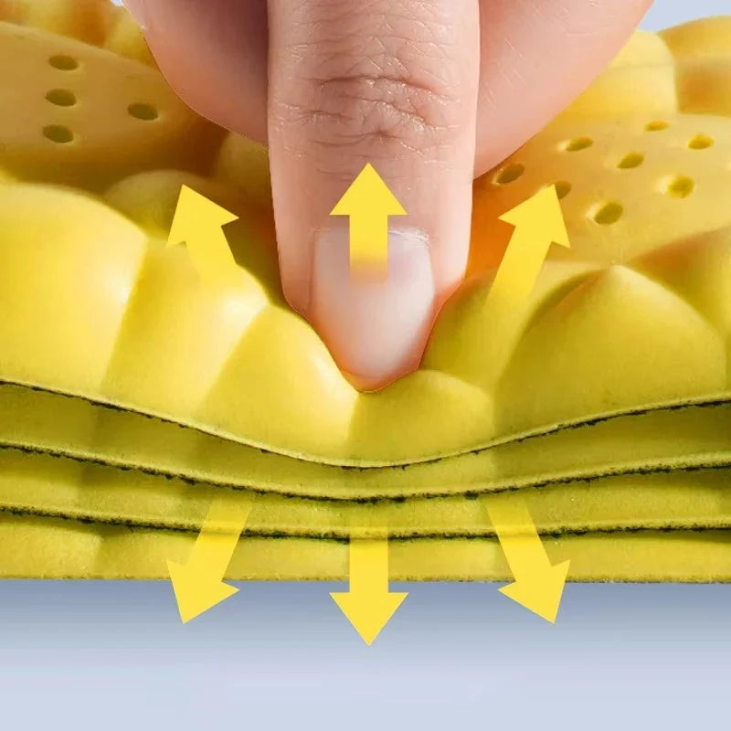 Yellow cushioned insole with perforated arch padding, close-up under finger