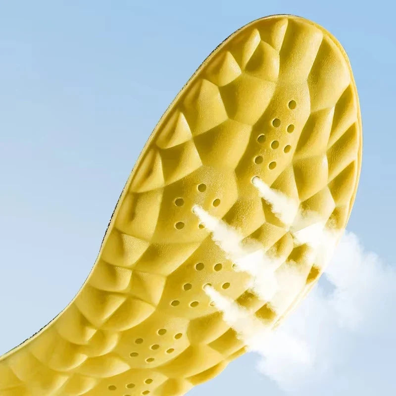 Yellow sport insole underside with tread-like pattern and perforation holes