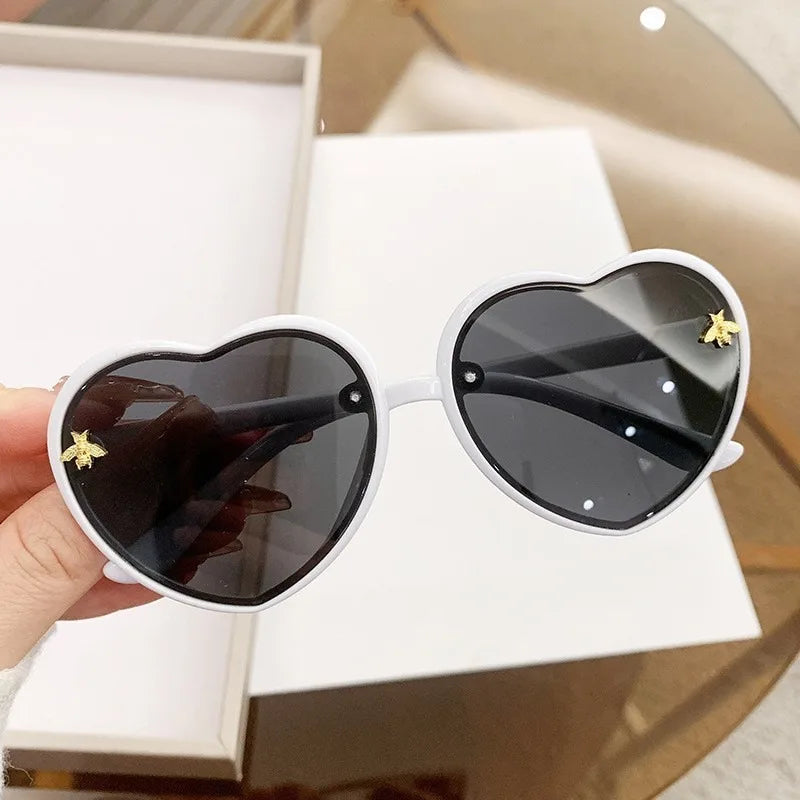 Kids heart sunglasses with white frames and dark lenses, star accents on arms