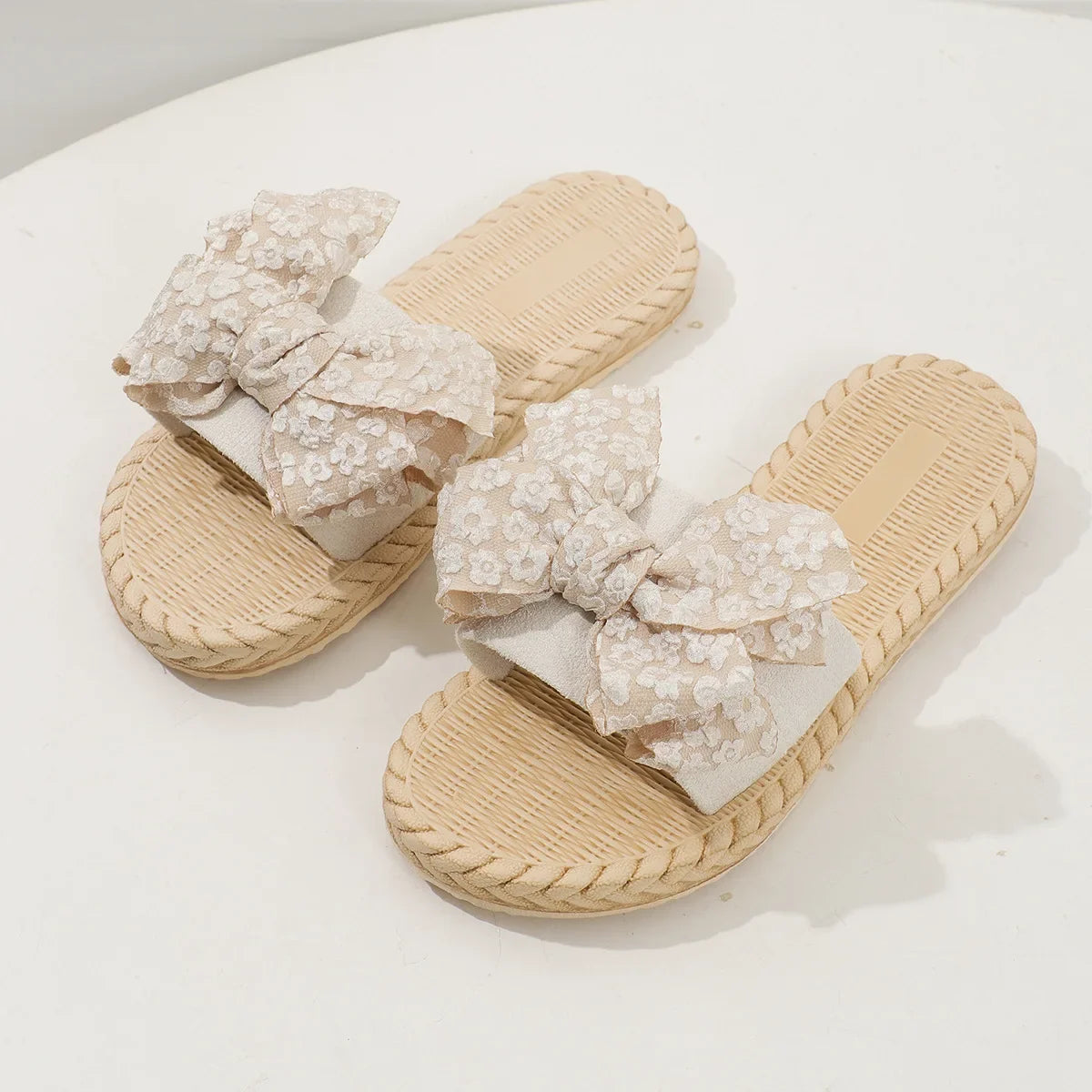 Cream lace bow flat slippers with woven textured soles and cushioned footbed