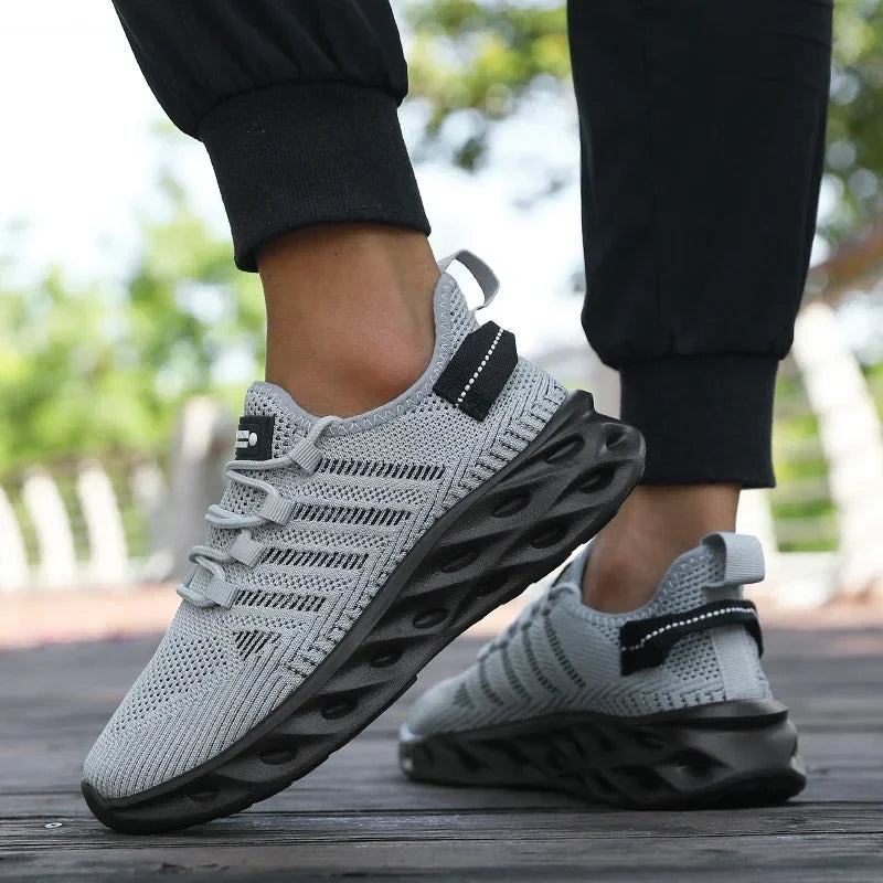 Light grey knit lace-up sports shoes with black thick tread sole and side pull tab