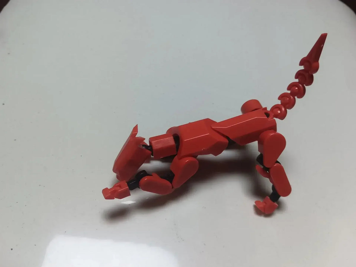 Red articulated robot action figure lying on its side with blue accessory pieces