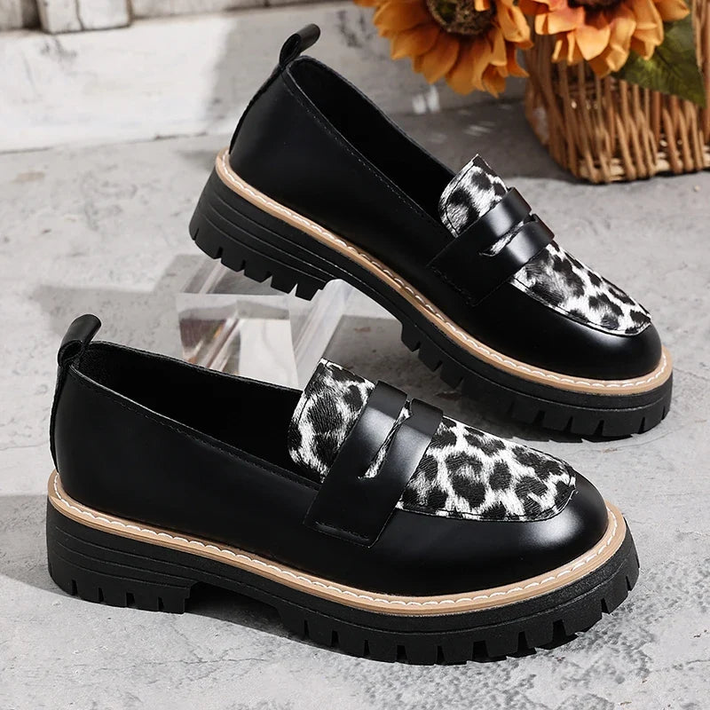 Women’s black slip-on loafers with leopard-print buckle detail and platform lug sole