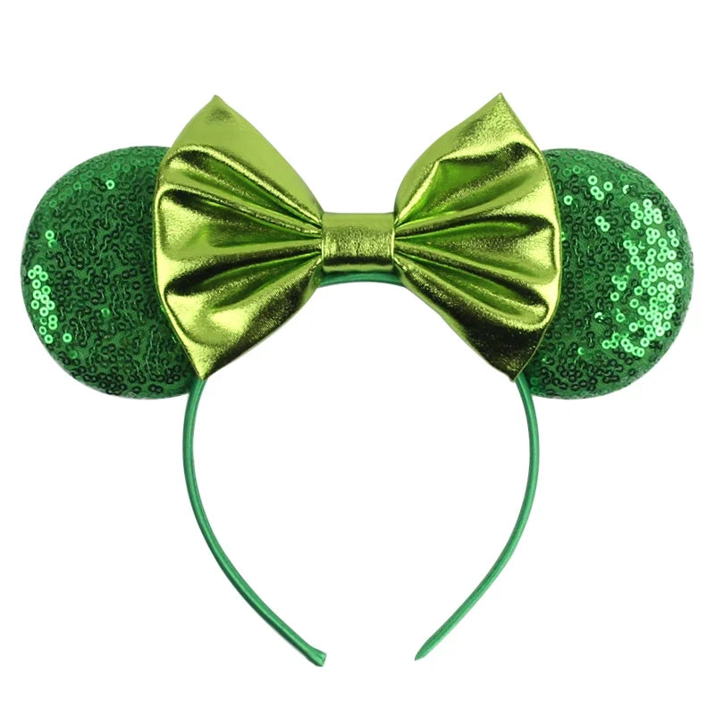 Green sequin Mickey-style ears headband with metallic green bow and curved band.